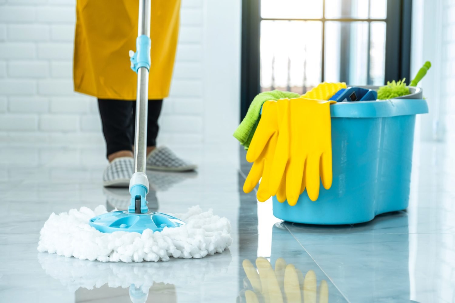 Wife housekeeping and cleaning concept, Happy young woman in blu Wife housekeeping and cleaning concept, Happy young woman in blue rubber gloves wiping dust using mop while cleaning on floor at home.